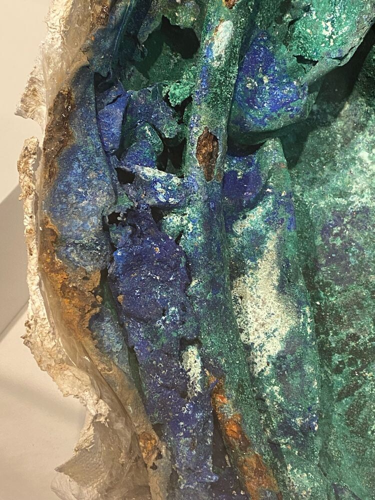 Part of a crushed copper cauldron, entirely covered in what looks like green malachite and deep blue azurite