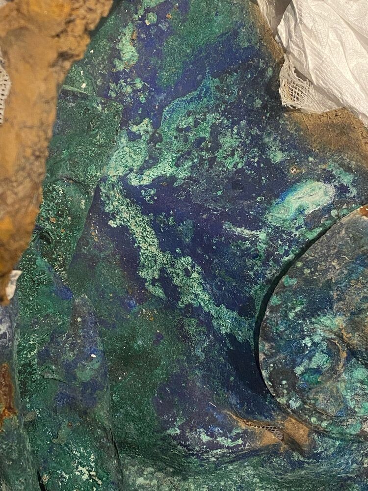 Part of a crushed copper cauldron, entirely covered in what looks like green malachite and deep blue azurite